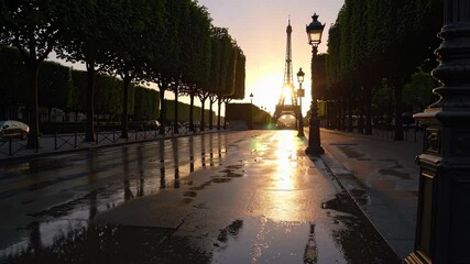 Enchanting sunset over city street with reflective puddles and vintage lamp posts