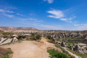 Aerial and panoramic view of the stunning and unique nature and rock formation, fairy chimneys of Cappadocia, Goreme, Turkiye on a beautiful spring blue sky day 
