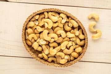 Organic cereals with straw plate on wooden table, close-up, top view.