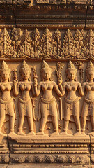 Fototapeta premium Architectural Stone Relief Depicting Figures Carved on Ancient Wall