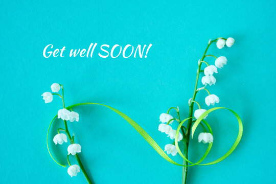 Lily of the valley flowers with green ribbon and text "Get well SOON!" on turquoise background