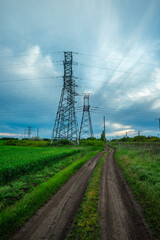 Rural Dirt Road Leading to Power Lines and Green Fields