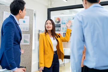 Obraz premium Asian business woman with friend In a modern office setting, a group of coworkers collaborate on renewable energy solutions, focusing on ESG principles and sustainable business practices