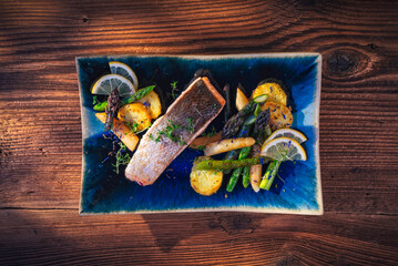 salmon with grilled white and green asparagus served on a plate with fried potato