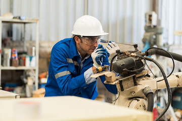 Robotic arm, Automatic robotic arm welding. Robotic manufacturing industry. Engineer setup, install, maintain, repair mechanism of operation of robotic arm in workshop