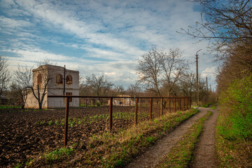 Dirt Road and Farm Field with a Distant Old Brick Tower and Utility Pole on the Horizon