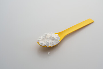 Close-up of tapioca starch or flour powder in spoon with white background