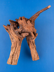A detailed close-up of natural wooden driftwood, crafted for enhancing aquariums or terrariums, set against a vibrant purple background.