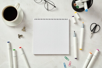 Top view of sketchbook and markers on marble table