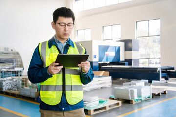 Asian engineers operating laser cutting machine