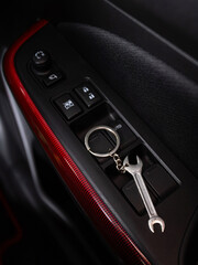 close up of metal wrench shaped keychain in car interior