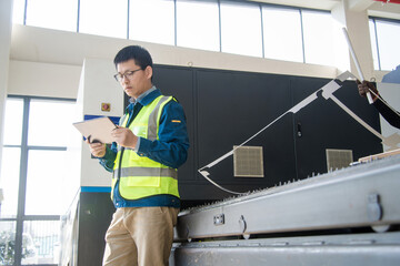 Asian engineers operating laser cutting machine