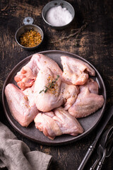 Raw chicken wings on black background.