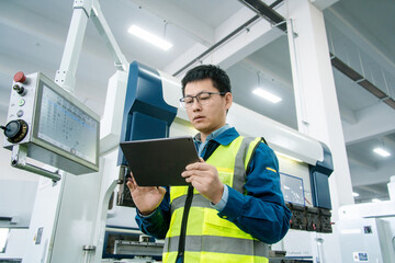 Mature man, computer or engineering in factory for machinery innovation, workshop or industrial...