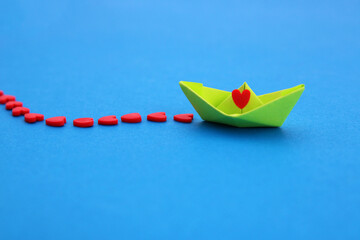 Green ship leaving a trail of red hearts