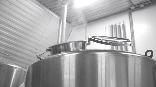 Brewing process in action, stainless steel tanks steaming in modern brewery setting.