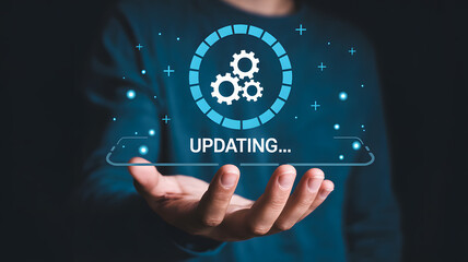 Person Holding a Virtual "Updating" Concept with Gear Icons and Progress Bar on Digital Screen
