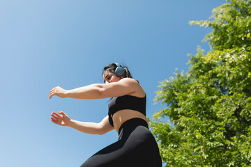 A woman performs arms and leg exercises for a sunny day in Zaragoza, Spain