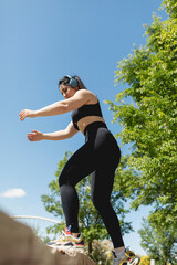 A young woman performs exercises to strengthen legs and buttocks, in a bench, during a sunny day, Zaragoza, Spain