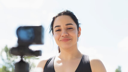 Closeup of a young woman that records herself on video, to explain to her followers, how to perform an exercise and sport workout