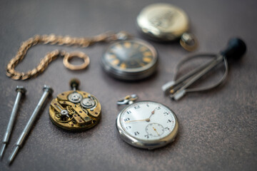 The mechanism of the pocket watch on the table. The workplace of a watchmaker.