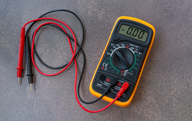 An electronic multimeter with wires and probes on the table. A device for measuring voltage.