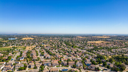 Drone image of Antioch’s residential district featuring curved roads, clustered homes, and distant green hills under a bright blue sky. Mount Diablo is visible in the distance.