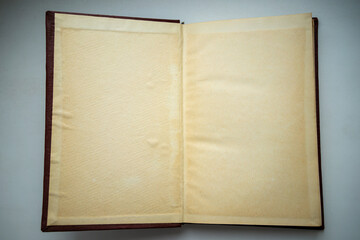 An old, yellowed book is open on the table.The texture of the yellowed paper in the document.