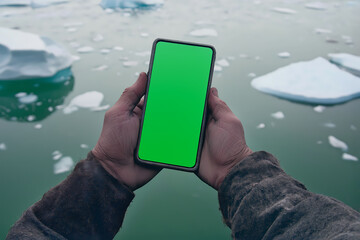 High-tech phone in calloused hands by icy waters