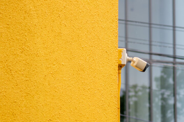 Security Camera Mounted on Yellow Building Wall