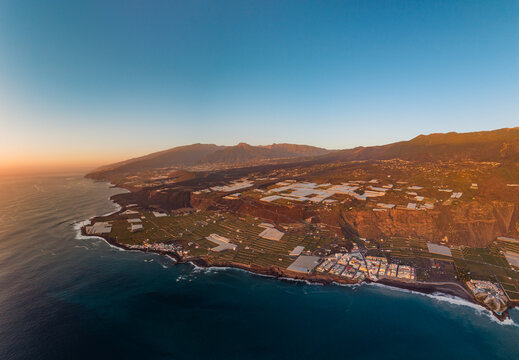 Aerial view of puerto naos town with banana fields and tajogaite volcano overlooking the coastline, La Palma Island, Canary Islands, Spain.