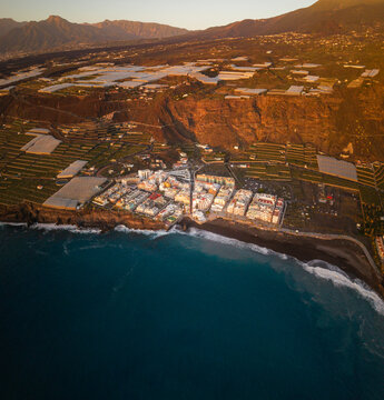Aerial view of puerto naos town with beautiful beach, hotel, banana field, and avocado tree during sunset, La Palma Island, Canary Islands, Spain.