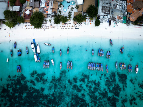 Aerial view of thai traditional boats in the blue lagoon at sunset beach, Koh Lipe, Koh Lipe island, Thailand.