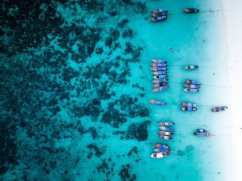 Aerial view of thai traditional boats in the blue lagoon at sunset, Koh Lipe, Koh Lipe island, Thailand.