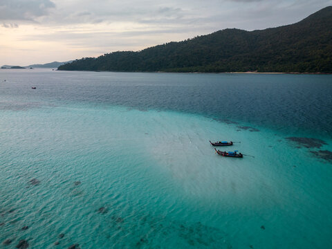 Aerial view of beach with turquoise water and fishing boats on Koh Lipe island, Mueang Satun, Thailand.