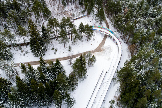 Aerial view of former Olympic bobsleigh track surrounded by snowy forest and pine trees, Sarajevo, Bosnia and Herzegovina.