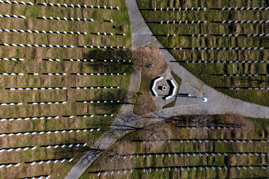 Aerial view of srebrenica memorial center with solemn tombstones and tranquil pathways, Potocari, Bosnia and Herzegovina.