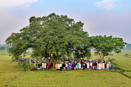 Satkhira, Bangladesh - 11 April 2024: Aerial view of people gathering for Eid prayer in a peaceful rural landscape with green fields and trees, Satkhira, Khulna, Bangladesh.