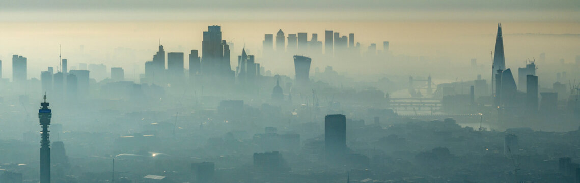Aerial view of a foggy cityscape with modern skyscrapers and towers, Westminster, England, United Kingdom.