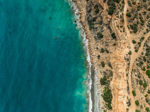 Aerial view of beautiful rocky cliffs and serene turquoise sea with waves, Pissouri, Limassol, Cyprus.