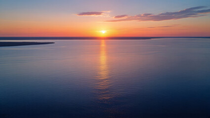 Beautiful sunset over calm sea with orange sky and reflections