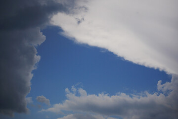 strange cloud hole in triangular shape forming an open blue sky area