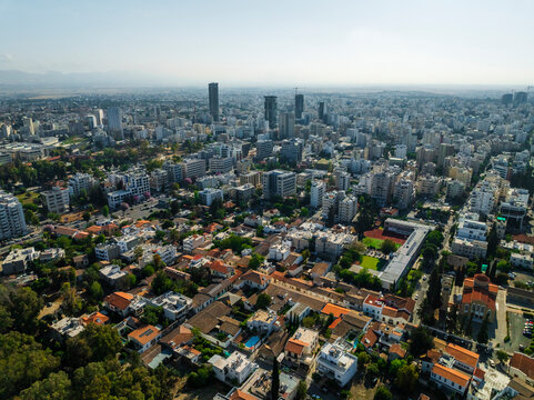 Aerial view of vibrant cityscape with modern buildings and residential rooftops at sunset, Strovolos, Nicosia, Cyprus.