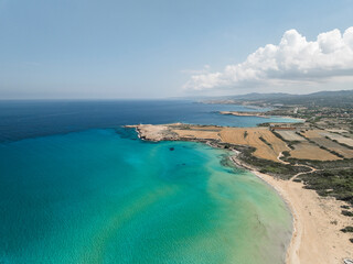 Aerial view of beautiful turquoise coastline with serene beach and clear sky, Aigialousa, Famagusta, Turkish Republic of Northern Cyprus.
