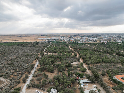 Aerial view of ancient Salamis with serene forest and picturesque cityscape under cloudy sky, Agios Sergios, Famagusta, Turkish Republic of Northern Cyprus.