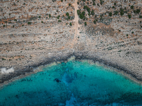 Aerial view of beautiful rocky coastline with crystal clear turquoise water and scenic cliffs, Cyclops Cave, Paralimni, Famagusta, Cyprus.