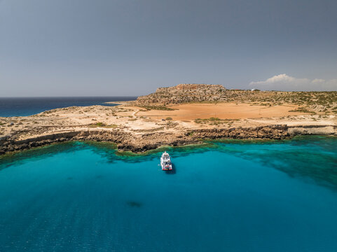 Aerial view of the blue lagoon with turquoise water and rocky shore, Cape Greco Peninsula, Agia Napa, Famagusta, Cyprus.