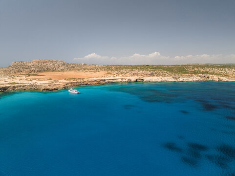 Aerial view of the beautiful blue lagoon with clear water and rocky cliffs, Cape Greco Peninsula, Agia Napa, Famagusta, Cyprus.