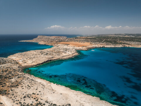 Aerial view of the beautiful blue lagoon surrounded by the scenic coastline and tranquil sea, Cape Greco Peninsula, Agia Napa, Famagusta, Cyprus.