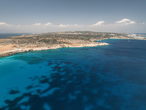 Aerial view of beautiful blue lagoon with clear turquoise water and scenic coastline, Cape Greco Peninsula, Famagusta, Cyprus.